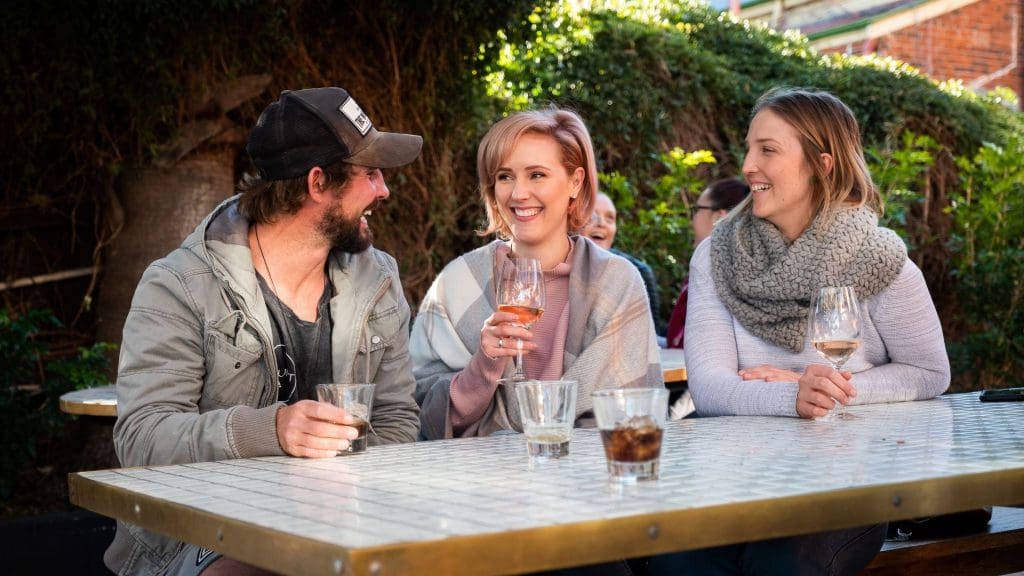 three young people enjoying a drink in the beer garden at the Tamworth Hotel